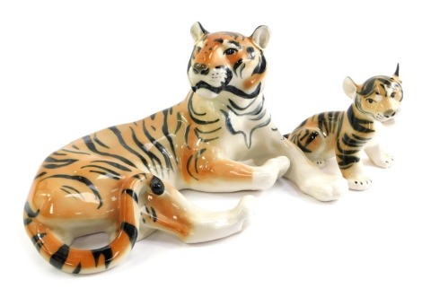 A Russian Lomonosov porcelain model of a recumbent tiger, 16cm high, and a tiger cub, 12cm high.