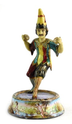 An early 20thC painted tinplate figure of a juggler, mounted on a circular base, hand painted with figures, 13cm high.