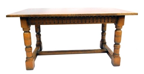 An oak rectangular refectory table, with gouged carved frieze, on turned legs and flat plain stretchers, 76cm high, the top 152cm x 84cm.