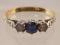 A stone set dress ring with central cornflower blue sapphire flanked by two tiny diamonds to shank s