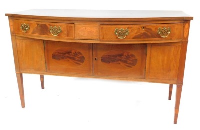 An early 20thC mahogany and figured mahogany bow fronted sideboard, the top with boxwood inlay and cross banding above two frieze drawers, the base with two cupboards, on square tapering legs, 83cm high, 135cm wide, 60cm deep.