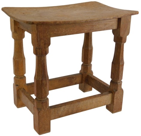 A Robert 'Mouseman' Thompson of Kilburn oak stool, with rectangular curved seat, raised on turned legs with mouse carving united by stretchers, 38cm high, the top 40cm x 27cm.