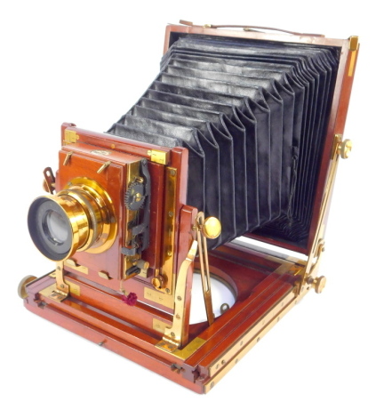 An early 20thC Thornton Pickard half plate camera, the mahogany case numbered 10382, with time and instantaneous lens and brass fittings, with various glass plates, in canvas case, with folding oak tripod.