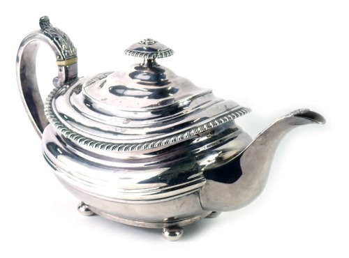 A Victorian silver teapot, with acanthus leaf handle, and rectangular rose moulded top, with a fluted border and shell capped spout, on bun feet, London hallmarks rubbed, 22.80oz.