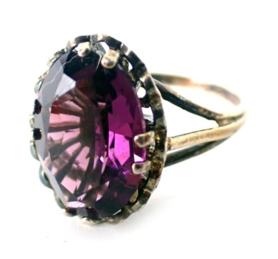 An amethyst dress ring, set with oval amethyst in four double claw setting with petalated border on a raised basket, yellow metal stamped 9kt, ring size L, 3.5g all in.