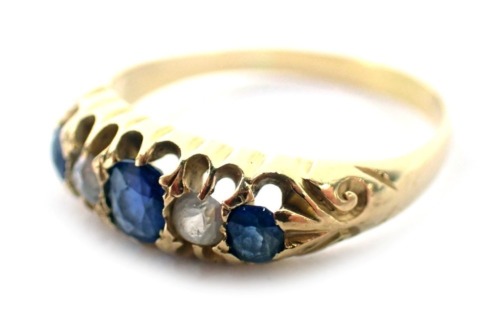 A sapphire and diamond half hoop dress ring, set with oval cut sapphires and round brilliant cut diamonds, each in claw setting, with scroll design shoulders, yellow metal unmarked, ring size L½, 2.8g all in.