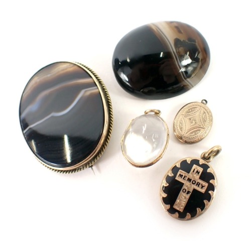 Agate set brooches, a Victorian enamel 'in memory' locket, a plated locket, and a rock crystal pendant. (5)