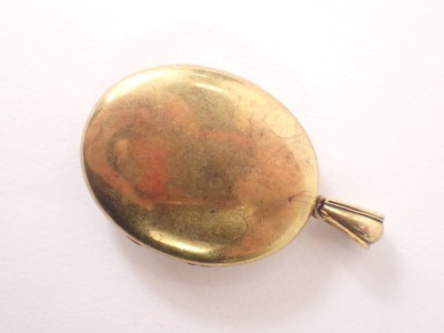 An Edwardian pinchbeck oval locket, with arched top and scroll outer border with a vacant shield, 13.4g all in. (AF) - 2