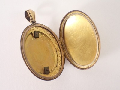 An Edwardian pinchbeck oval locket, with arched top and scroll outer border with a vacant shield, 13.4g all in. (AF) - 3