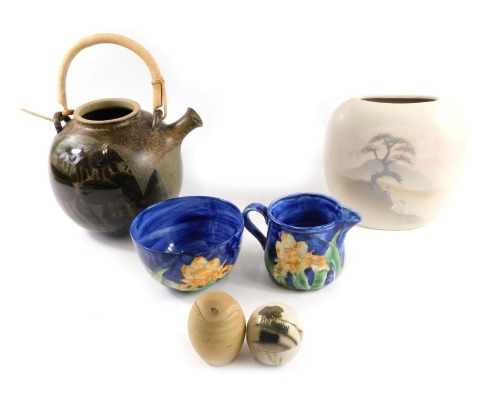 A group of studio pottery, comprising a painted blue bowl stamped Idonia, and matching milk jug, egg cup, brown teapot, and a leaf shaped vase, the teapot 18cm high, the largest vase 21cm high. (6)