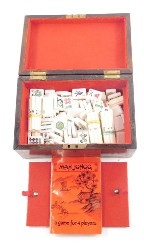 A 19thC mahogany cased mah-jong set, the outer box with brass inlay and central shield, opening to reveal a red lined interior with instructions and plastic markers, 12cm high, 23cm wide, 15cm deep.