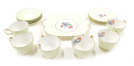 An Aynsley part tea service, decorated on a lime green ground, with hand painted decoration of flowers, to include cake plate, five side plates, five saucers, and six tea cups.