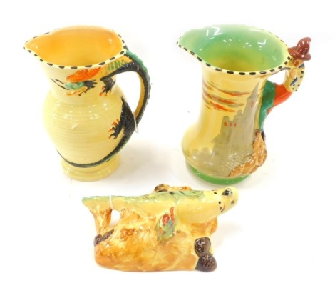 Two Burleighware jugs, comprising one decorated with a dragon handle and the other with the pied piper, and a Burleighware budgerigar wall mask. (3) 