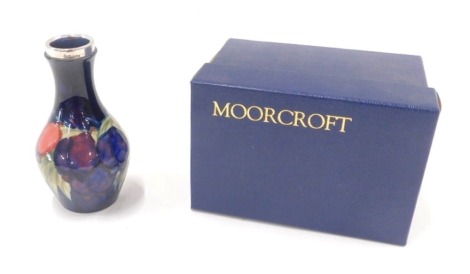 A Moorcroft vase, with a silver plated collar on a blue fruit blossom pattern, numbered 372, 15cm high, boxed.