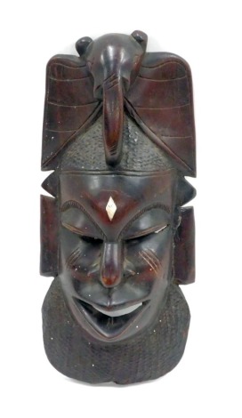 Tribal Art. An African carved wall mask, with bone diamond shaped inlay, 41cm high.