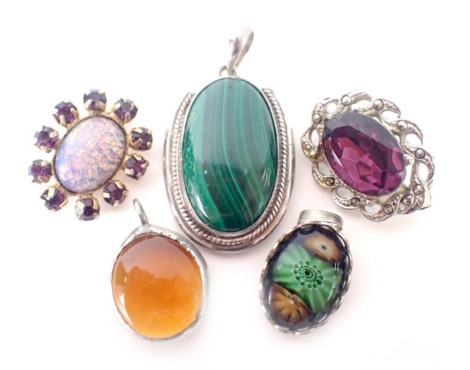 A group of costume brooches and pendants, comprising a malachite pendant in white metal frame stamped 925, an imitation amber pendant in plated frame, and two brooches. (5)