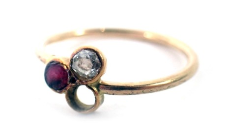 A multistone dress ring, the central section set design of three stones, two present to include diamond and ruby, on a yellow metal band, unmarked, ring size M, 1.4g all in.