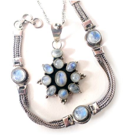 A moonstone set jewellery suite, comprising star pendant on twist frame, white metal stamped 925, pendant 4.5cm high, chain 44cm long, and matching bracelet 17cm long, white metal stamped 925, 22.7g all in. (2)