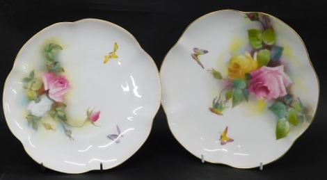 Two Royal Worcester cabinet plates, each with a fluted border with gilt highlights, and transfer printed decoration of pink and yellow roses with butterflies, 22cm diameter. (AF)