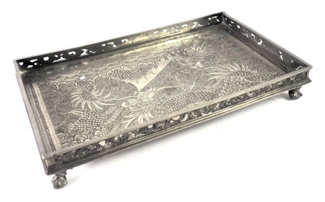 An eastern pewter rectangular card tray, with decoration of dragons, on a pierced border with ball and claw feet, 4cm high, 25cm wide, 15cm deep.