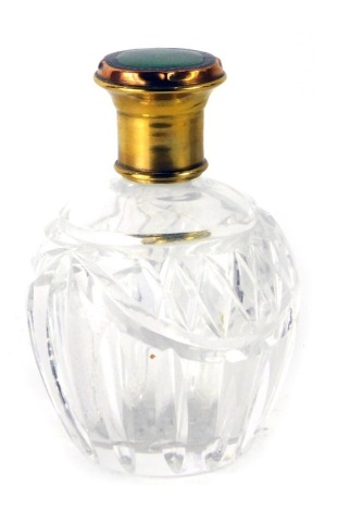 A cut glass, gilt and enamel scent bottle, set with green and blue enamel on copper and brass top, 12cm high.