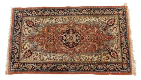 An Eastern rug, on an orange ground with medallions, 159cm x 90cm.