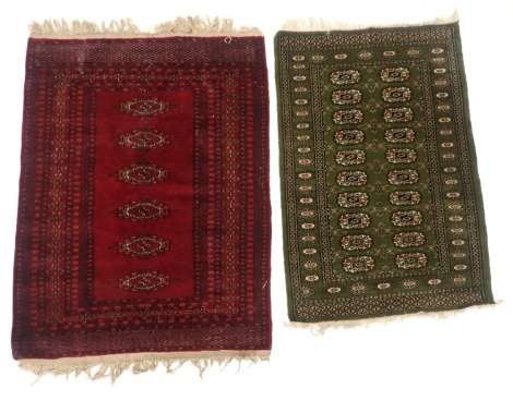 An Afghan rug, with a design of medallions on a green ground, and a red ground belouch type rug, 119cm x 80cm and 97cm x 126cm. (2)