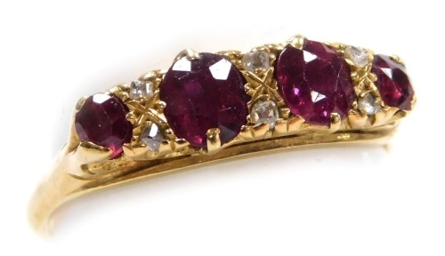 A ruby four stone ring, set with pairs of diamonds at intervals, in a claw mount, yellow metal, stamped 9ct, size P, 3.0g.