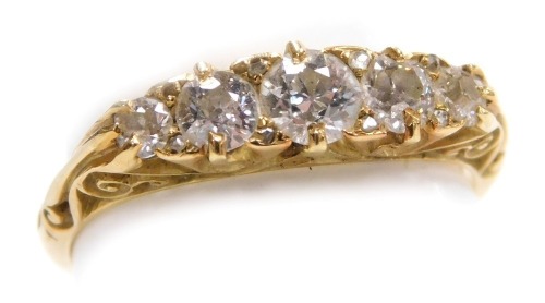 An Edwardian 18ct gold and diamond five stone ring, set with five diamonds graduated to the centre, in a scrolling claw mount, approximately 0.5 carat, size R.