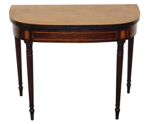 A George III mahogany demi-lune fold over card table, with satinwood crossbanding, opening to reveal a baize interior, raised on turned legs, 73cm high, 91cm wide, 45cm deep.