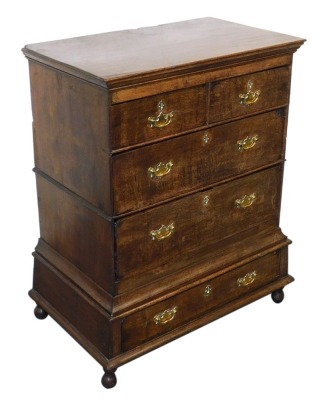 An 18thC oak chest on stand, the outswept pediment over two short above two long drawers, the base with a further long drawer, raised on bun feet, 117cm high, 90.5cm wide, 56cm deep.