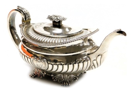 A George III silver teapot, of semi fluted form, with shell capped heart shaped reserve, monogram engraved, raised on four leaf scroll and lion's paw feet, London 1816, 19.18oz.