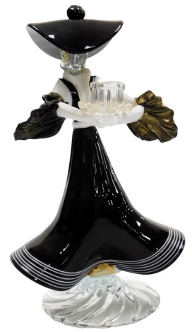 A Murano glass candlestick, of a figure of a lady wearing a black and white striped frilled dress, oversized hat, and puffed sleeves, 33cm high.