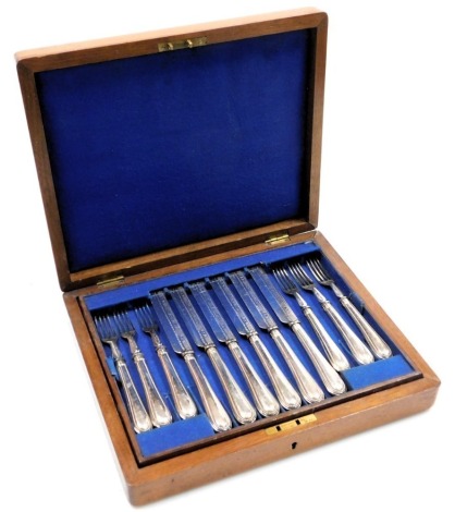 A Victorian silver plated fruit canteen of cutlery, comprising twelve beaded handled knives and forks, walnut cased.