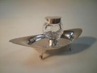 An Edwardian silver inkwell with glass receiver by Asprey & Co. of navette form on four scrolled fee