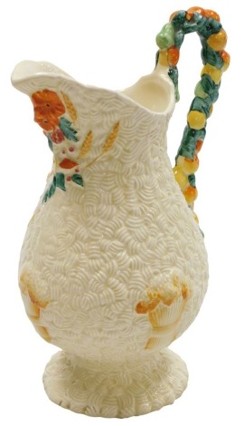 A Clarice Cliff for Newport Pottery harvest jug, of baluster form, with a fruit moulded handle, and spout moulded with poppies and corn, printed marks, 25cm high. (AF)