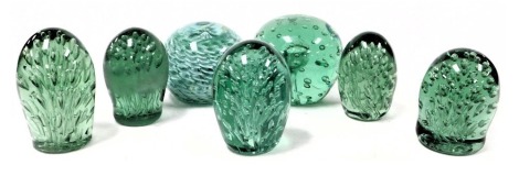 A group of 19thC green glass dump paperweight, each with profuse air bubble inclusions, together with a later glass paperweight, with green and white basket weave decoration. (7)