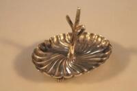 An Edwardian silver ring tree on swirling scalloped base and bun feet