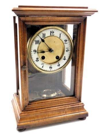 A late 19thC mahogany cased mantel clock, brass circular dial with enamel chapter ring bearing Arabic numerals, eight day movement with coil strike, the case of architectural form, raised on bun feet, with pendulum and key, 30cm high, 20cm wide, 13.5cm de