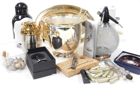 A group of bar items, including a silver plated wine cooler, Swing-a-way ice crusher, soda siphon, Metrokane penguin jug, and a wine thermometer.