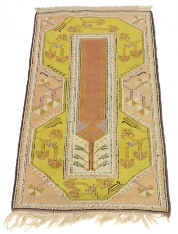 A Turkish pink and yellow ground tree of life rug, the tree within a central rectangular field, against a ground of stylised branches and dogtooth border, 142cm x 87cm.