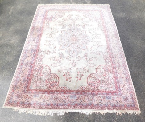 A Tabriz cream ground rug, with a central floral medallion within a field of scrolling flowers, within repeating floral and foliate borders, 3741cm x 274cm.