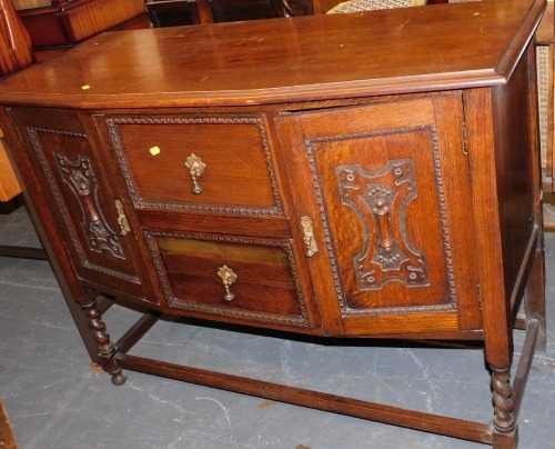 An oak sideboard of two drawers flanked by two doors, raised on stretcher below.