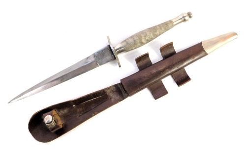 A Fairbairn-Sykes fighting knife, with cross hatched handle, the blade marked Wilkinson sword, in leather scabbard, length of blade 16.5cm, 29.5cm long overall.