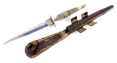 A Fairbairn-Sykes fighting knife, with cross hatched handle, in leather scabbard, length of blade 17cm, 30cm long overall.