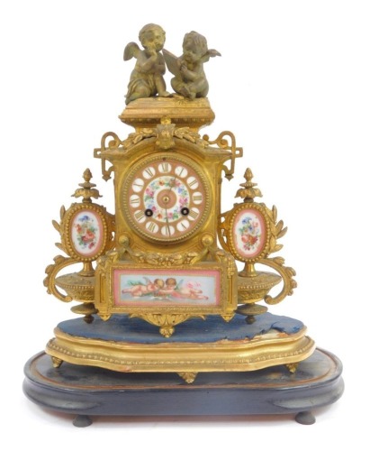 A 19thC French gilt metal mantel clock, the circular enamel dial bearing Roman numerals and decorated with flowers, eight day, the case surmounted by two cherubs, above an ornate floral and scroll cast base with floral painted enamel roundels and plaque t