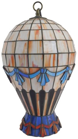 A Tiffany style pendant light shade, modelled as a hot air balloon, in pale pink with banded blue and red bows, 47cm high including fitting.