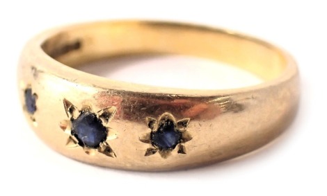 A 9ct gold half hoop dress ring, set with three illusion set sapphires, each in star setting, ring size Q½, 3.6g.