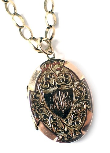 A 9ct gold pendant and chain, the curb link chain with safety chain, 50cm long, with a yellow metal locket stamped 9ct, with floral scroll engraving, and central shield bearing the initials NB, 2.5cm high, 10.3g.