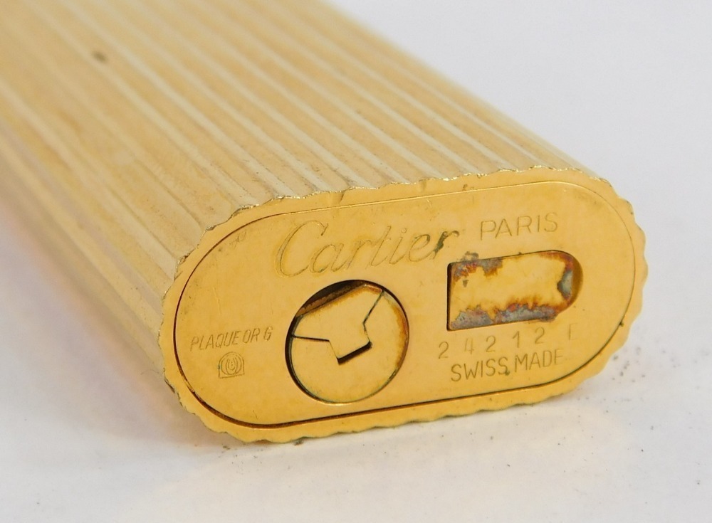 A Must De Cartier gold plated lighter of ribbed design serial